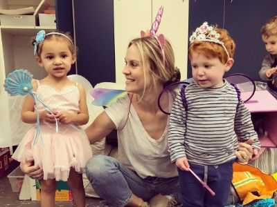 Cassidy Boesch is playing with a boy and a girl dressed as fairies.